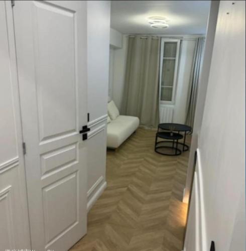 - un salon avec une porte blanche et un canapé dans l'établissement Studio Coup de Cœur Ménilmontant, à Paris