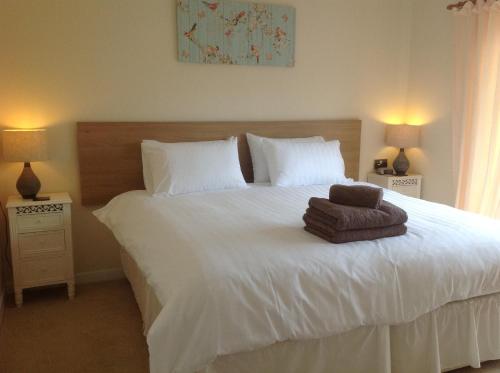 una camera da letto con un letto bianco e un asciugamano sopra di Hazeldene Apartment Unit a Perth