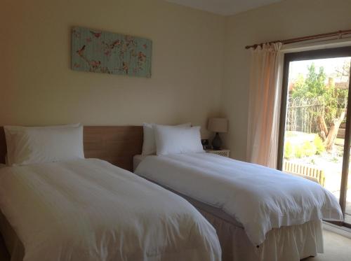 two beds in a bedroom with a window at Hazeldene Apartment Unit in Perth