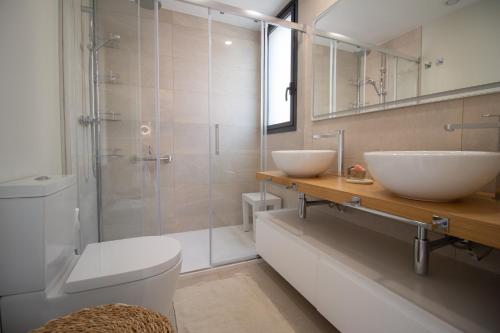 een badkamer met twee wastafels en een glazen douche bij Luxury penthouse with private pool in El Campello