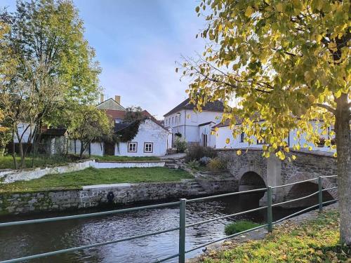 a house next to a river with a bridge at Chaloupka u Mostu sv Jana v centru Vodňan in Vodňany