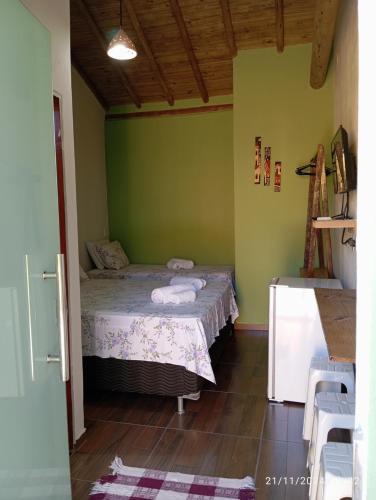 a bedroom with a bed in a room with green walls at Suíte Trancoso in Trancoso