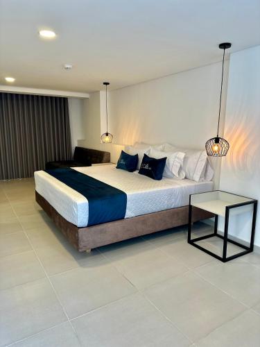 a bedroom with a large bed and a table at Hotel ECO 44 in Medellín