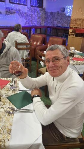 a man sitting at a table with a glass of wine at Hotel Veles in Querciola