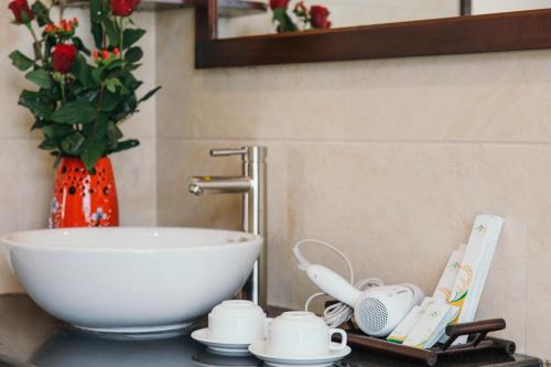 un bancone del bagno con ciotola e lavandino di Hoi An Golden Rice Villa a Hoi An