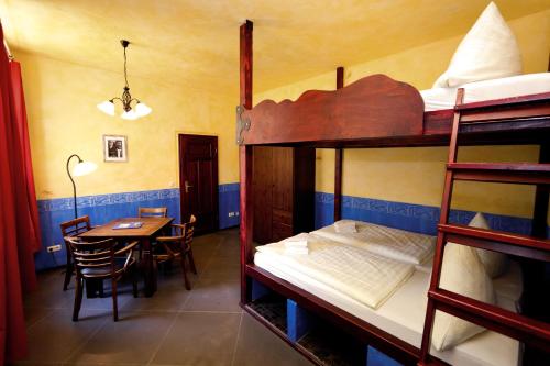 a room with bunk beds and a table and a table and chairs at Gästehaus Mezcalero in Dresden