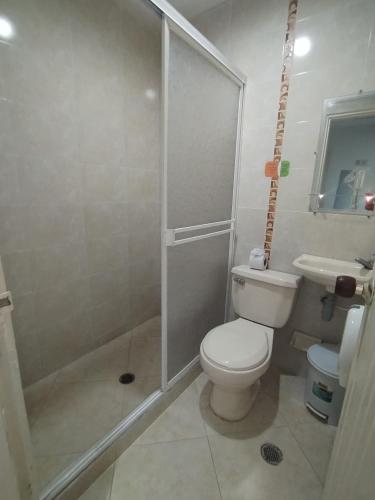 a bathroom with a shower and a toilet and a sink at Hotel La Leyenda Vallenata in Valledupar