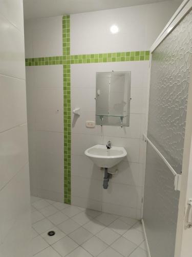 a white bathroom with a sink and a mirror at Hotel La Leyenda Vallenata in Valledupar