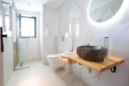 a bathroom with a sink and a toilet at Oriens Villas in Palaiokhóri