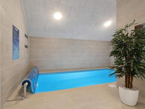a swimming pool in a room with a potted plant at Luxury Retreat by Hasmark - By Traum Ferienwohnungen in Otterup