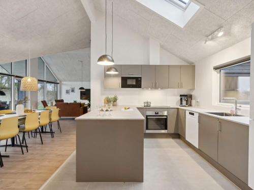 an open kitchen and dining room with yellow chairs at Luxury Retreat by Hasmark - By Traum Ferienwohnungen in Otterup