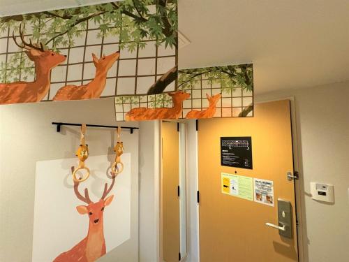 a room with paintings of deer on the wall at Henn na Hotel Premier Nara in Nara