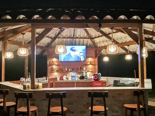 Tantiri River Resort في بويرتو مالدونادو: مطبخ مع بار مع تلفزيون بشاشة مسطحة