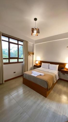 a bedroom with a large bed and a large window at Tantiri River Resort in Puerto Maldonado