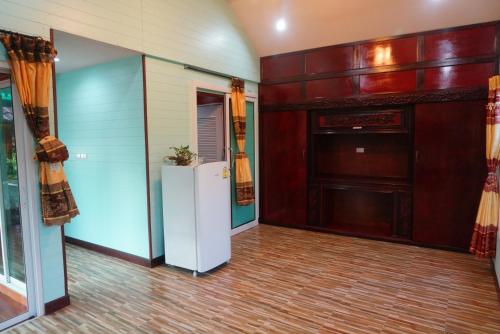 a living room with a refrigerator and a wall at Ruen Tai Boutique in Nai Yang Beach