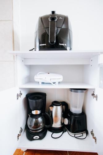 a coffee maker and a blender on a shelf at Residencial Mizinho Ap2 in Florianópolis