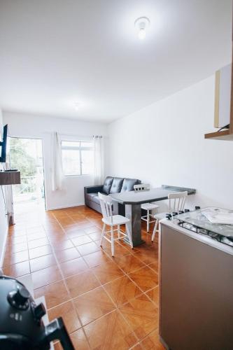 a kitchen and living room with a table and chairs at Residencial Mizinho Ap2 in Florianópolis