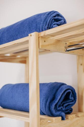 a stack of blue towels on a wooden shelf at Residencial Mizinho Ap2 in Florianópolis