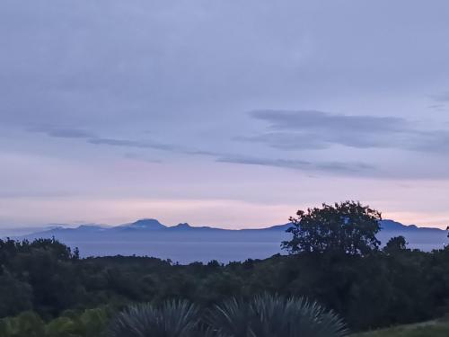 a view of the ocean and mountains at dusk at L'ASETA Paradise in Grand-Bourg