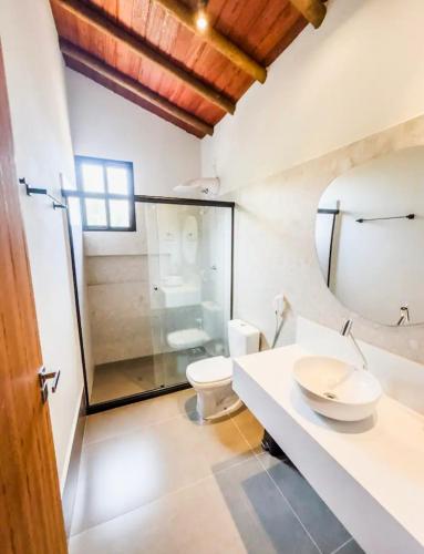 a bathroom with a toilet and a glass shower at Vila Tanrral in Lençóis