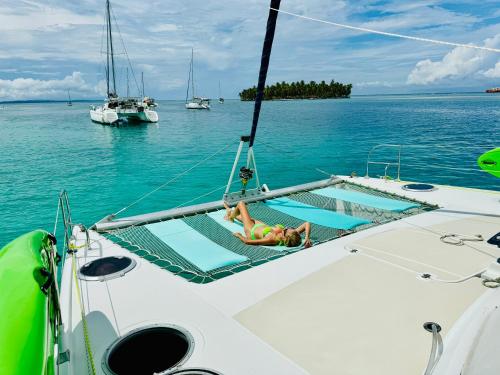 Eine Frau, die auf einem Boot im Wasser liegt. in der Unterkunft Catamaran Yoyo in Isla Wichitupo Grande