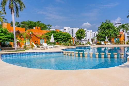 a swimming pool in a resort with palm trees and buildings at Family Condo with 3 Bedrooms Pool & Hot tub in Acapulco