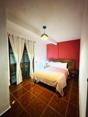 a bedroom with a bed and a red wall at Montecarlo in Toluca
