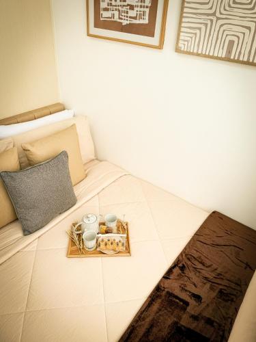 a bed with a tray with two mugs and a tray of food at Natural Haven at South in Manila
