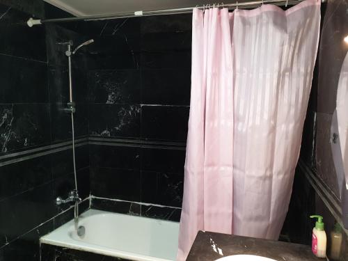 a bathroom with a tub and a pink shower curtain at City Bleu Maroc in Tangier