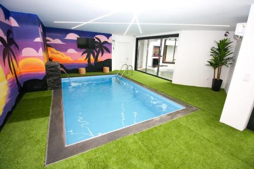 a large swimming pool in a room with green grass at Requinte House in Nogueira de Cravo