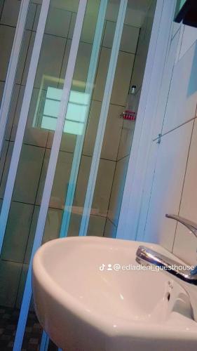 a bathroom with a white sink and a shower at Edladleni Guesthouse Quigney in East London
