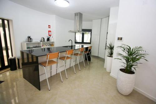 a kitchen with a black counter and chairs in a room at Requinte House in Nogueira de Cravo