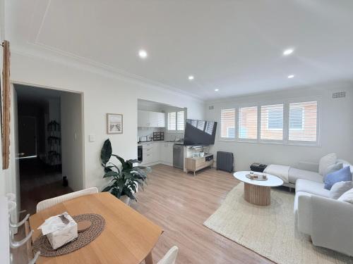 a living room with a couch and a table at Coogee Sunrise shared Apt with Parking & Work Desk in Sydney