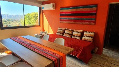 Camera con letto e parete arancione. di La Moradita Villa Carlos Paz a Villa Carlos Paz