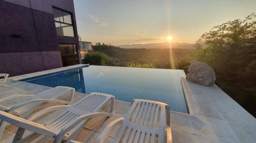 un gruppo di sedie sedute accanto a una piscina di La Moradita Villa Carlos Paz a Villa Carlos Paz