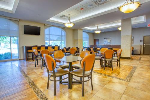 a dining room with tables and chairs and a television at Drury Inn & Suites San Antonio Near La Cantera in San Antonio