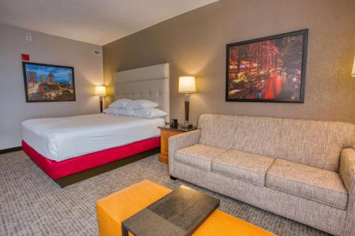 a hotel room with a bed and a couch at Drury Inn & Suites San Antonio Near La Cantera in San Antonio