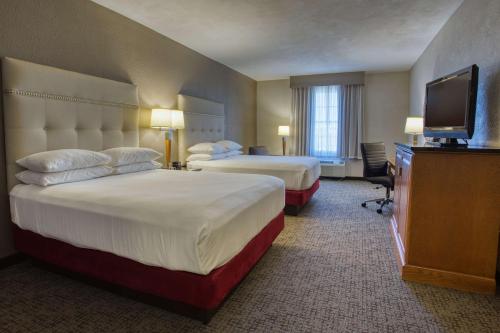 a hotel room with two beds and a flat screen tv at Drury Inn & Suites San Antonio Near La Cantera in San Antonio