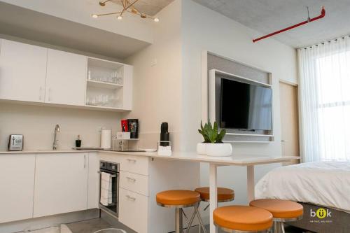 a kitchen with a table and stools in a room at Escalante Executive Studio AC in San José
