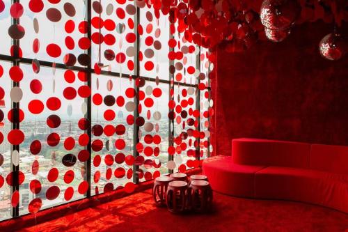 a room with a red couch and a window with red dots at Escalante Executive Studio AC in San José