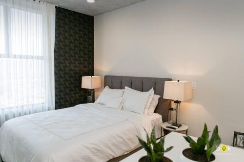a bedroom with a bed with two lamps and two plants at Escalante Executive Studio AC in San José