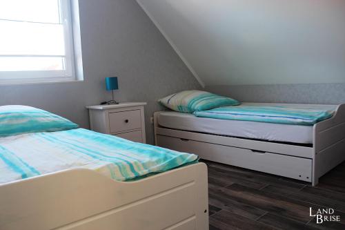 two twin beds in a room with a window at LandBrise in Petersfeld