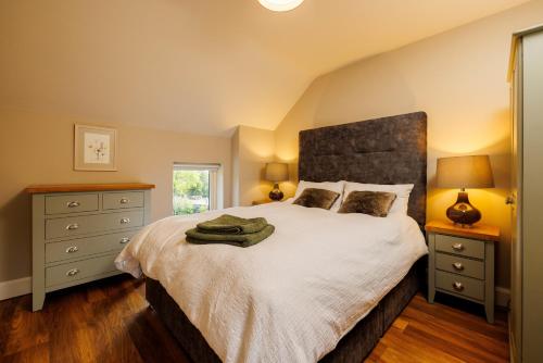 a bedroom with a large bed with a large headboard at Brigid's Cottage in Weatherstown