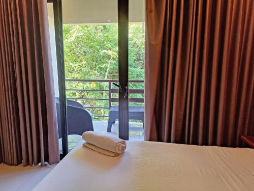 a hotel room with a bed with a towel on it at Infiniti Hotel in Puerto Viejo