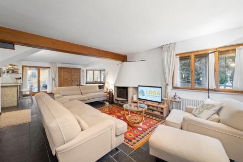 a living room with white furniture and a fireplace at Chesa Alvan - Surlej in Surlej