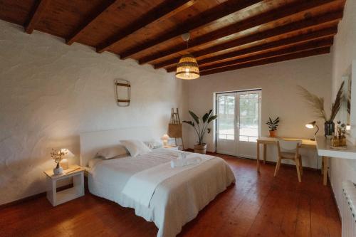a bedroom with a white bed and a wooden ceiling at NaNa House Ericeira - Yoga & Surf in Santo Isidoro