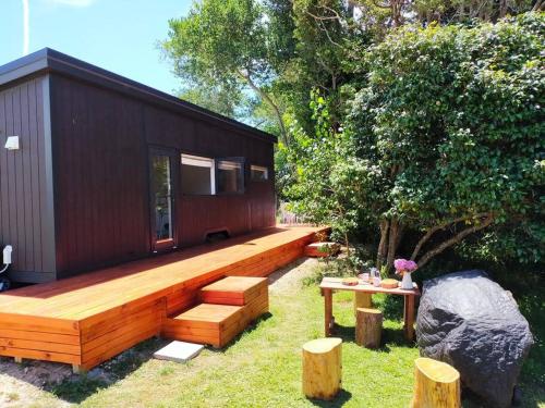 Casa pequeña con terraza y mesa en Penhill Hideaway, en Maxwell