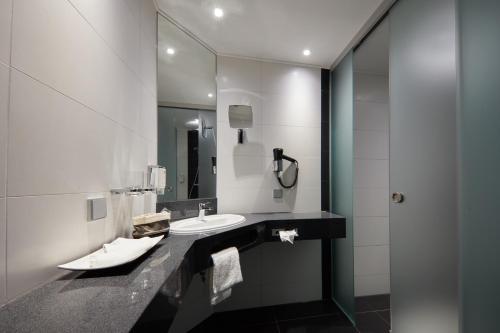 a bathroom with a sink and a mirror at Privathotel alte mühle Wolfsburg-Weyhausen in Wolfsburg