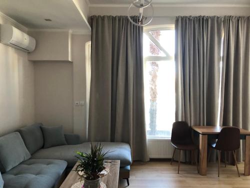 a living room with a couch and a table and a window at The sunny apartment Αριδαια-Λουτρά Ποζαρ in Aridaia
