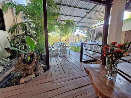 a wooden deck with a table and some plants at Infiniti Hotel in Puerto Viejo